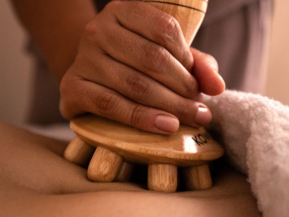 Maderotherapie mit Holzelement am Rücken